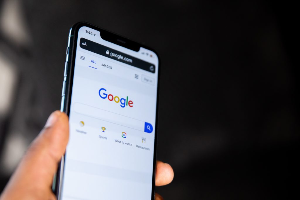 Person holding phone searching on Google